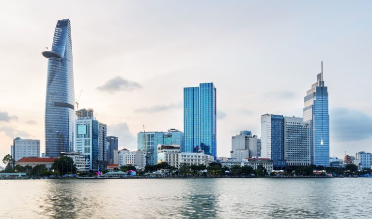 Ho Chi Minh City skyline with modern skyscrapers reflected in the Saigon River.