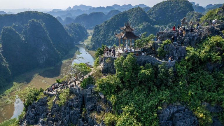 Temple perched on limestone karst overlooking river valley in Ninh Binh, Vietnam