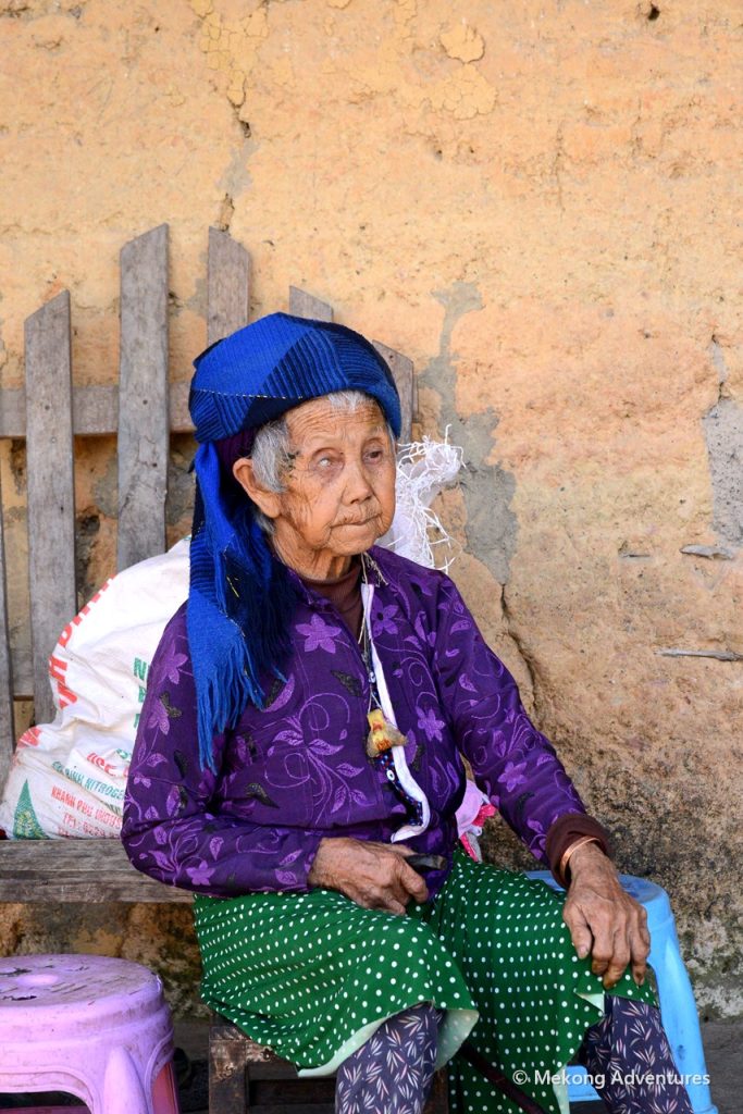 Elderly Hmong woman in a blue headscarf in Then Pa village